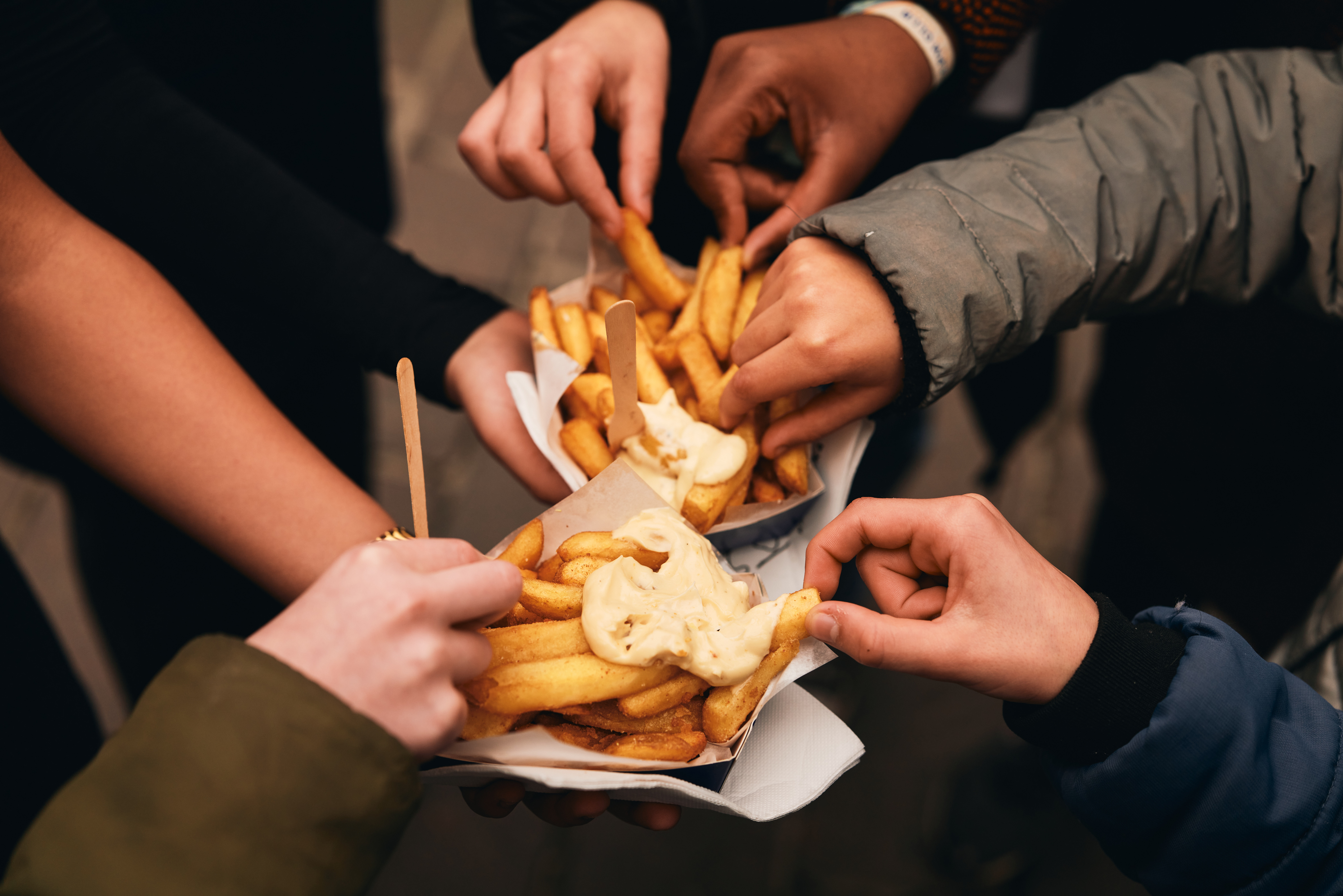 Server holding a Frites Atelier tray of Frites and sauces